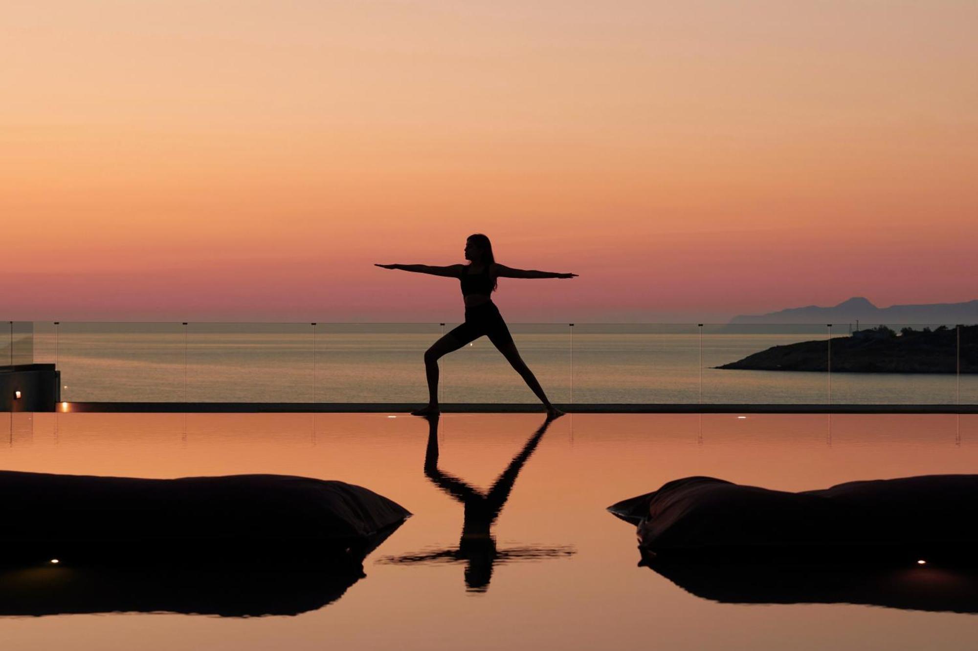 Minos Palace Resort - Adults Only Ájosz Nikólaosz Kültér fotó A woman practicing yoga at sunset